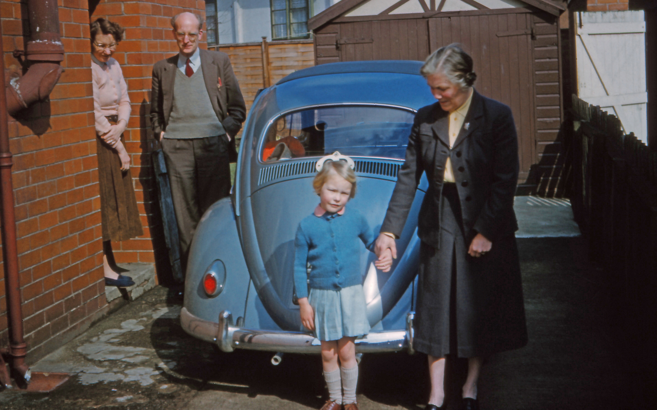 The cover images shows a small child, standing in front of a nineteen fifties Volkswagen Beetle, parked in the driveway of a modest brick-built house, holds an older woman's hand and looks directly into the camera.