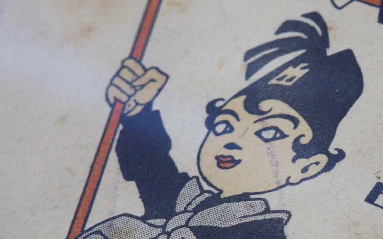 A cartoon of a boy in uniform holding a book and waving a flag.