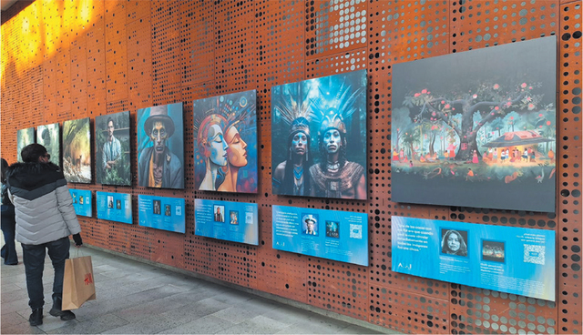 A photograph of people looking at exhibition materials comprising a row of large square AI-generated images with rectangular panels below giving copious details about the image and the person who made it. The exhibition is on the outside of a building along a walkway and the images are attached to a metal wall with lots of regular holes in it.